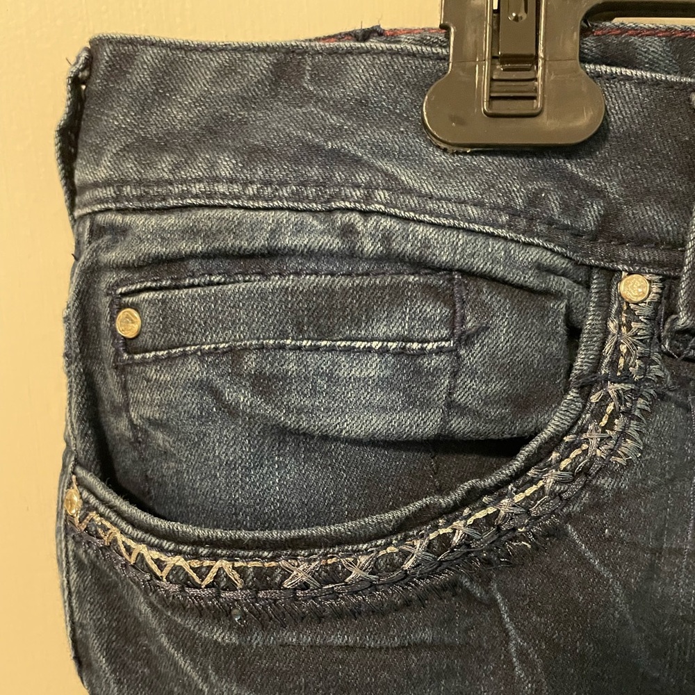 Women’s blue jeans with distressed look and rips.